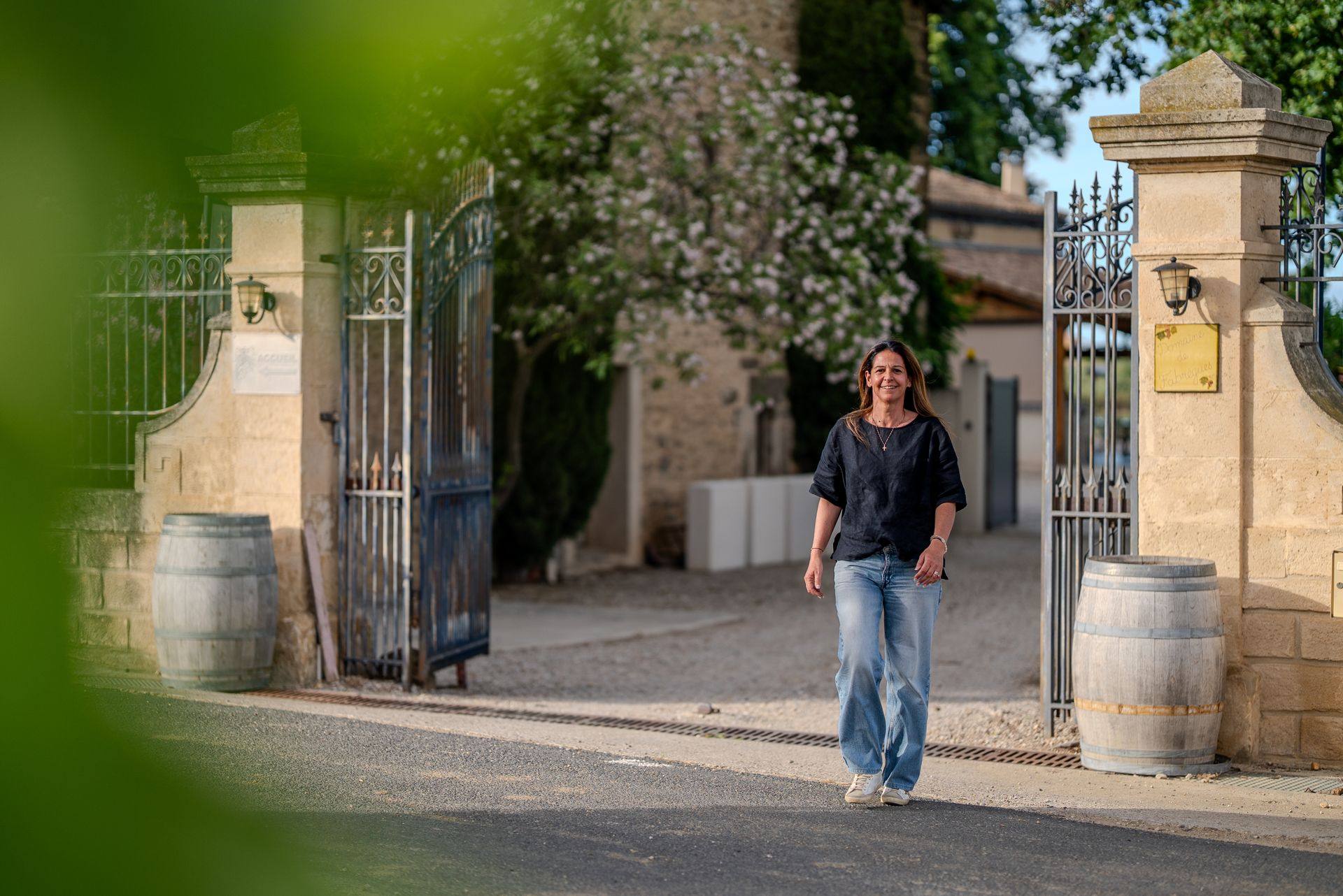 Carine Pichot devant le portail d'entrée du Domaine de Fabrègues