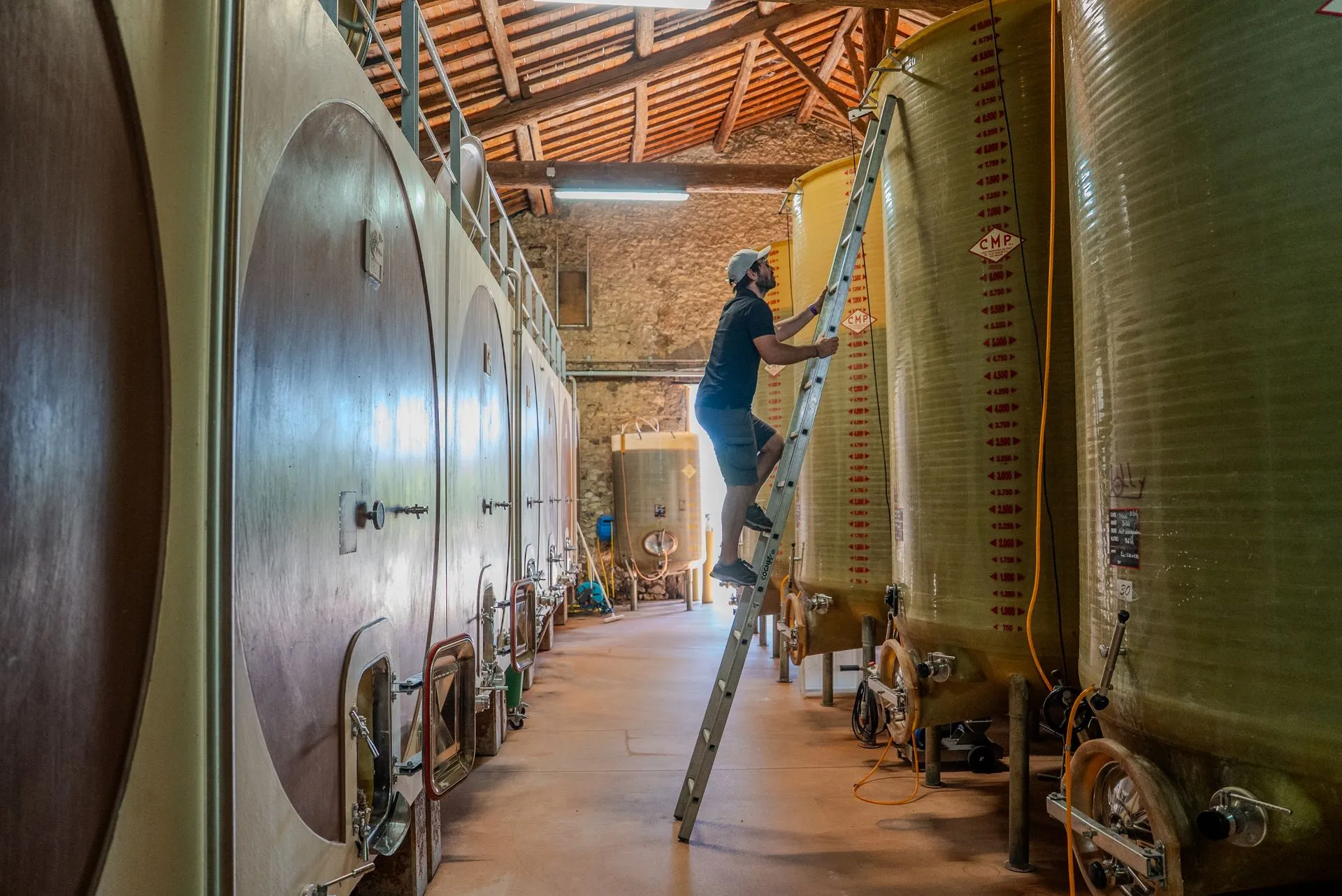 Arthur dans la cuverie du Domaine de Fabrègues, entre les cuves